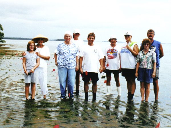 group photo of people standing in shallow ankle-deep water.