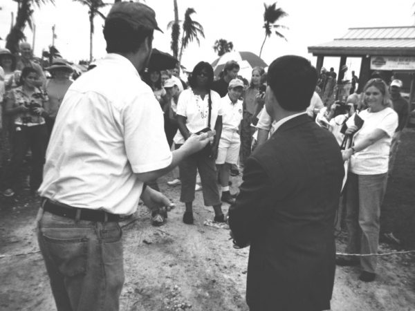 group of people watching a ribbon cutting ceremony