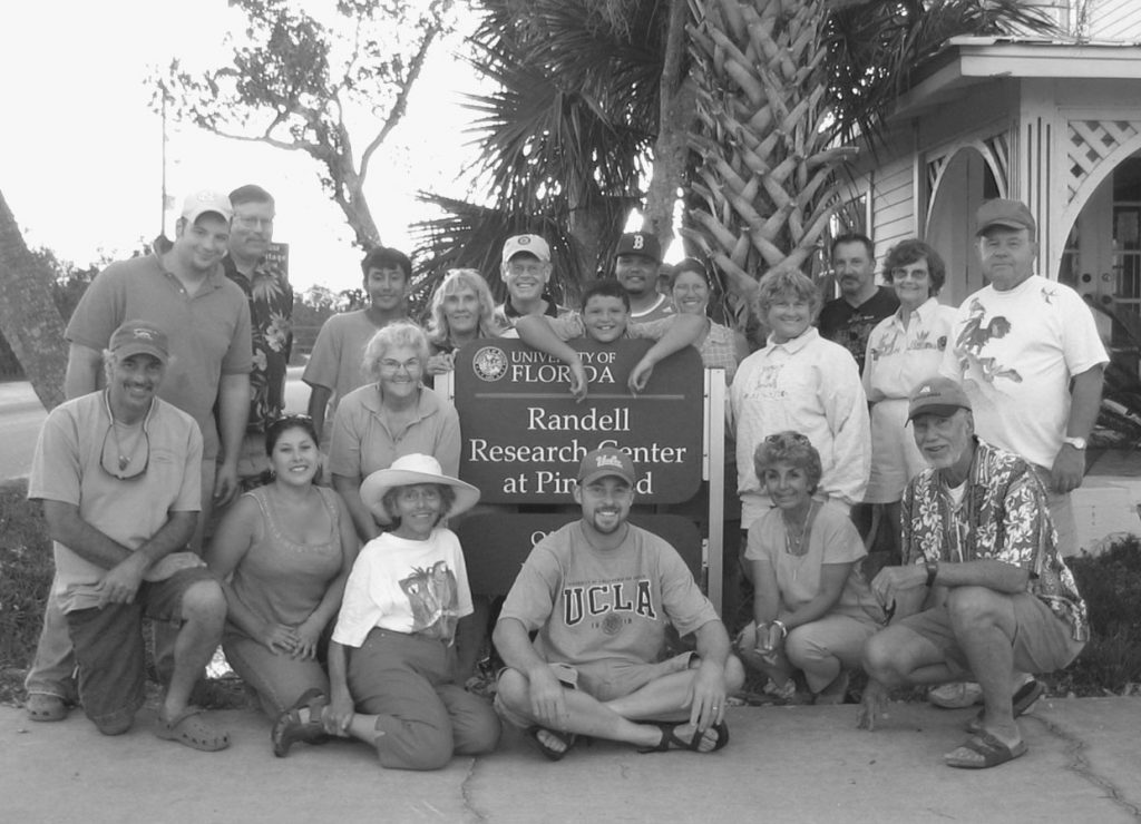 group photo, many volunteers surround the RRC sign