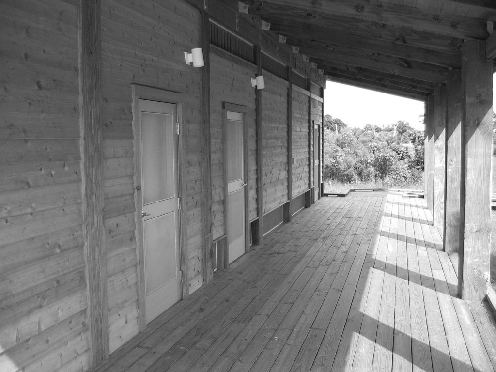 black and white photo of a wooden deck and the outside of a building