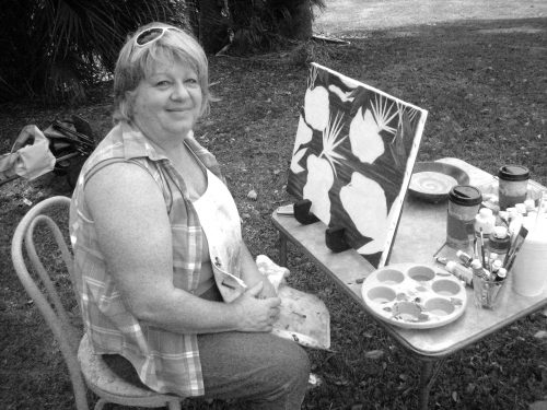 artist sitting in front of a half-finished canvas