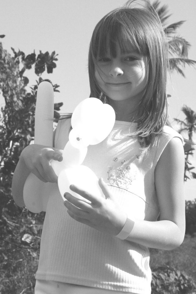 young girl holding a ballon animal