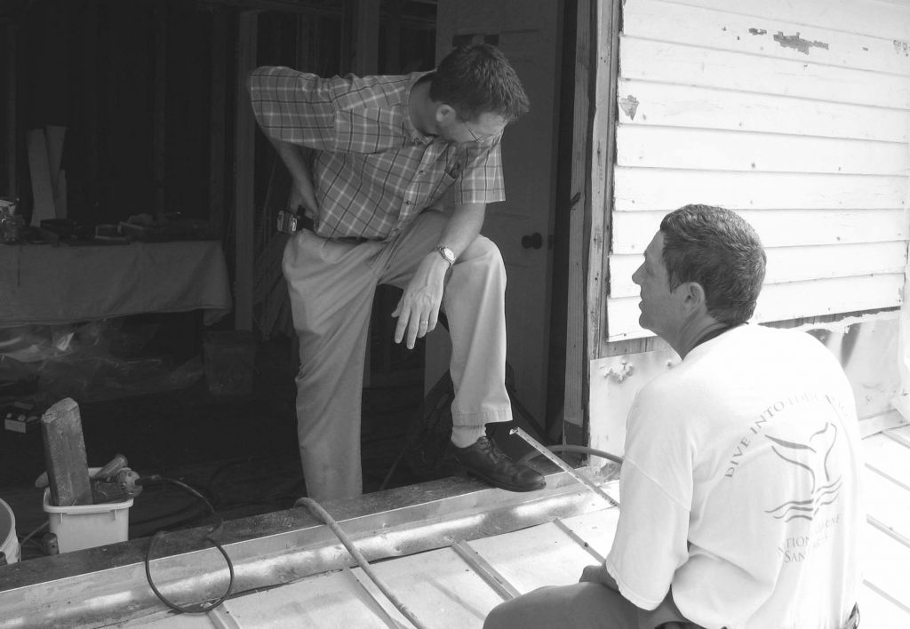 two people speaking in a house under construction