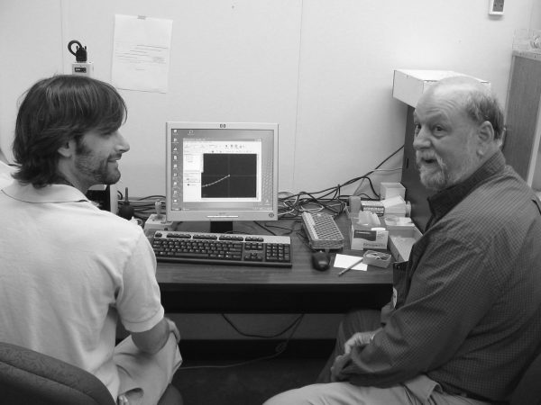 two researchers sit in front of a computer