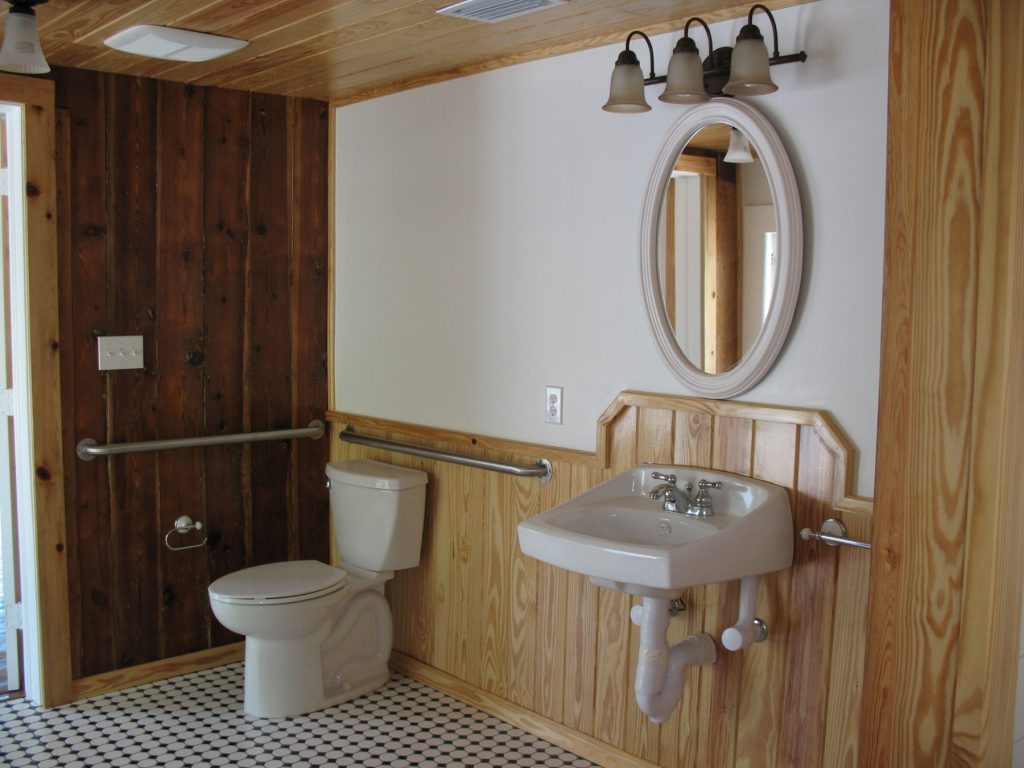 Bathroom with toilet sink and oval mirror