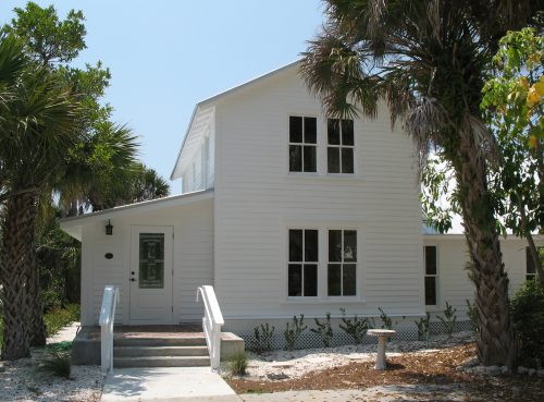 two story white house with an enclosed front porch