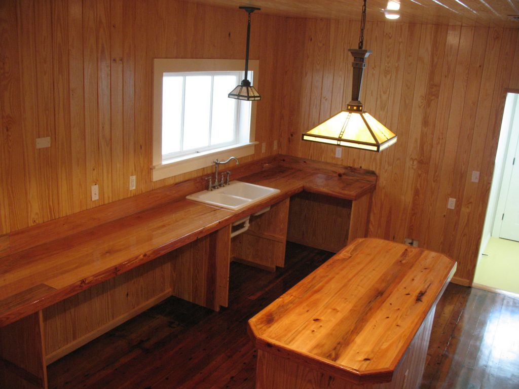 Empty room with pine wood floor wall and ceiling. The wood is highly polished and reflective