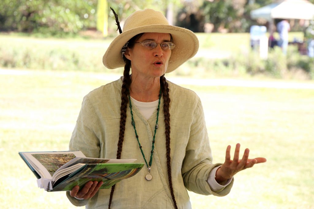 person holding an open book and speaking