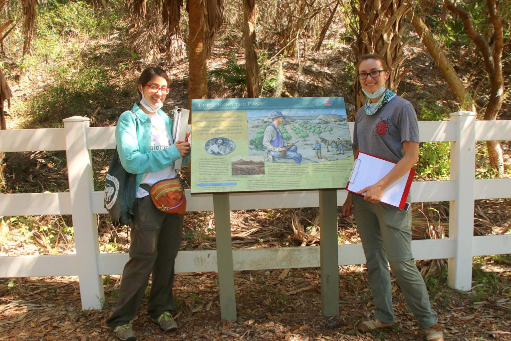 two people standing next to trail display