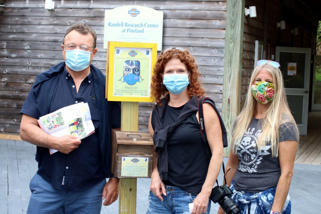 three people wearing masks standing outside of the Randell Research Center