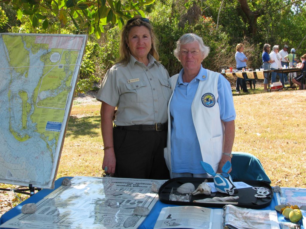 two people stand behind a display table. One person is wearing a ranger uniform