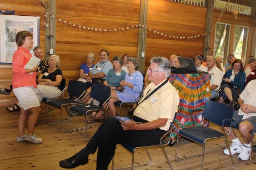 people sitting in chairs listening to a speaker