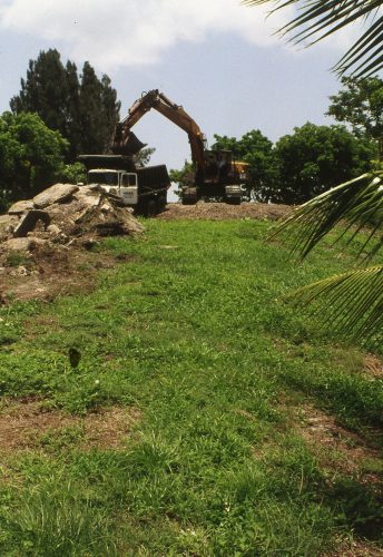 large backhoe and dump truck at the top of a hill