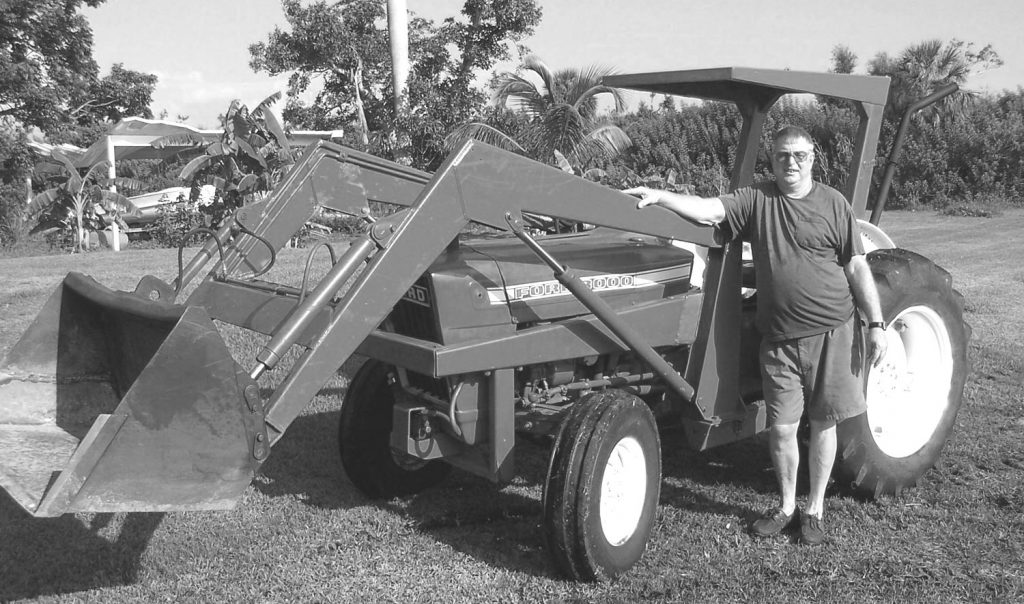 man stands next to a tractor