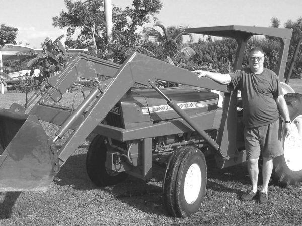 man stands next to a tractor