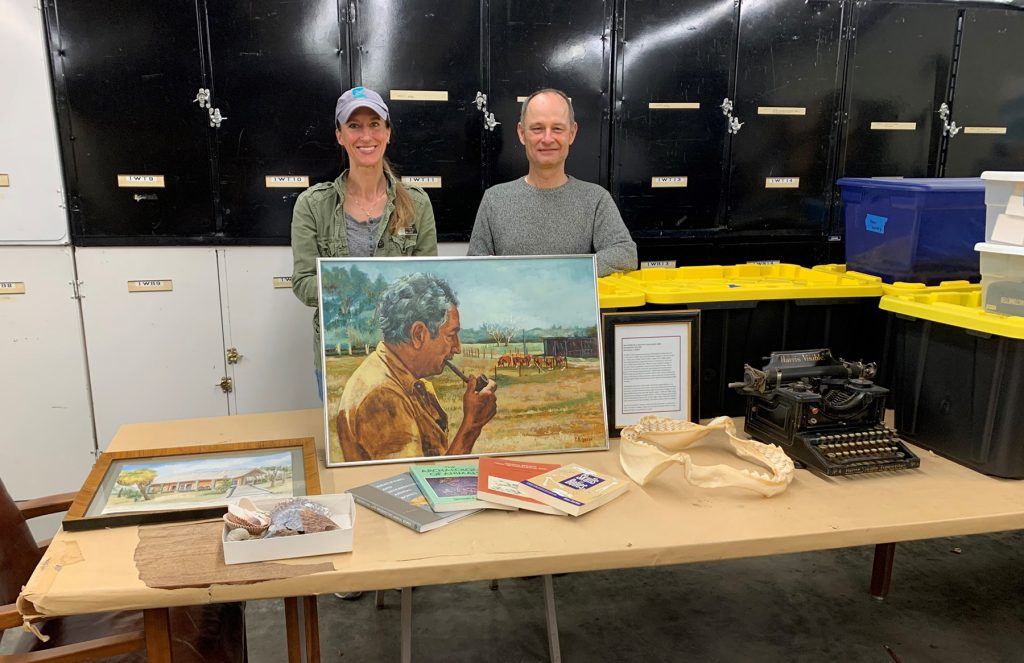 two people behind a table with many items displayed on it