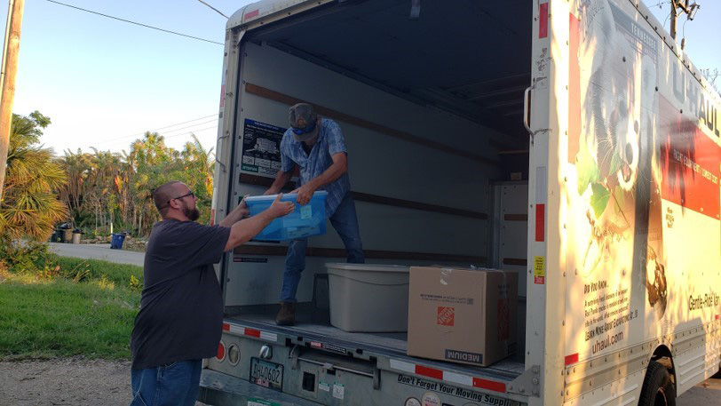 people moving boxed into a truck