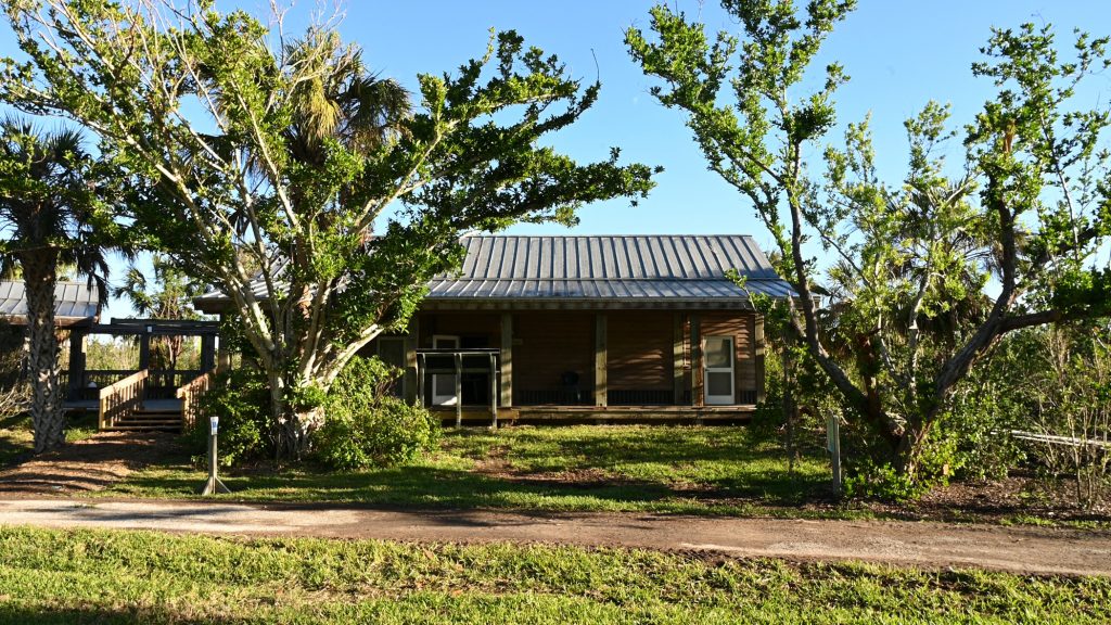 wood building with tin roof and covered porch