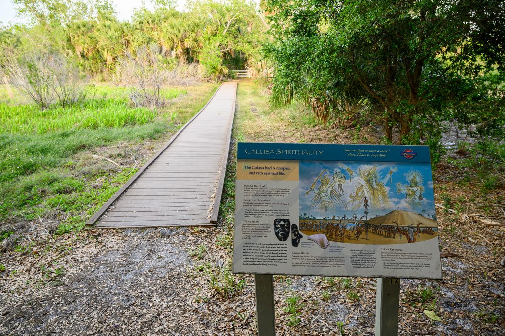 Display information panel about Caluse Spirituality set next to the wood boardwalk along the Calusa Heritage Trail at RRC.