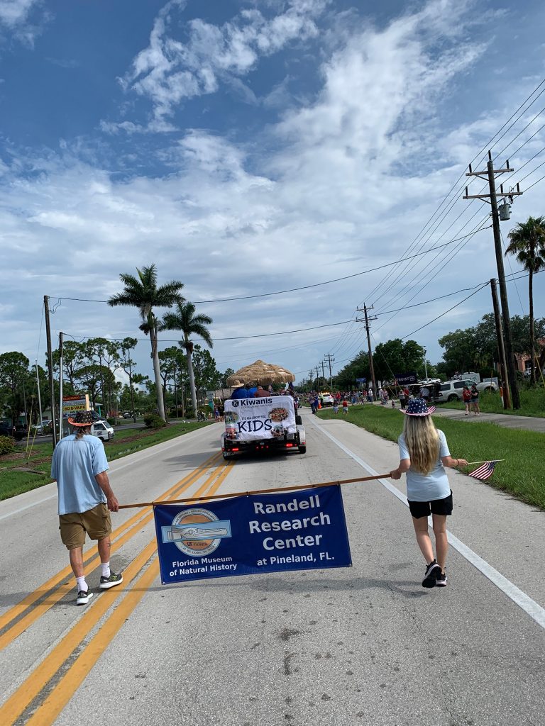 Fourth of July parade two people walking with an Randell Research Center banner