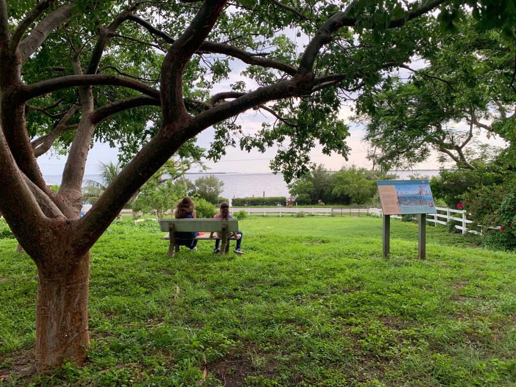 two people sitting on the bench on the top of a mound overlooking the Pine Island sound