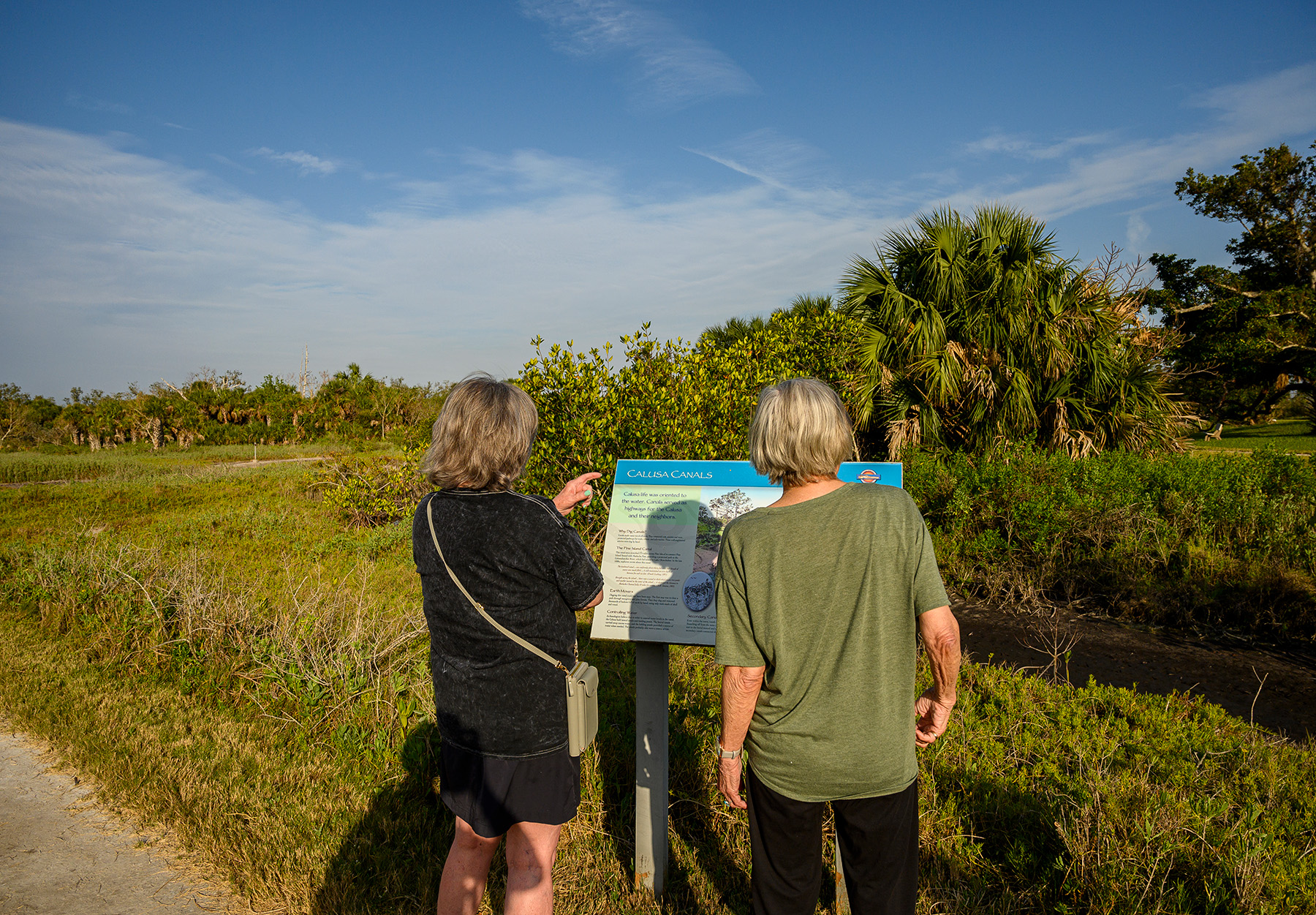 two visitors reading the signs along the trail