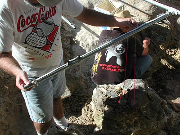 Figure 4. Museum staff member Richard Hulbert determines the relative depth and location of a rhino femur within the grid system at Tyner Farm. Image taken on November 13, 2003.