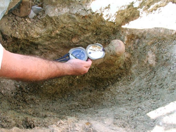 Figure 5. Museum staff member Richard Hulbert uses a Brunton compass the determine the bearing (measured in degrees east of north) of a rhino femur. Image taken on November 13, 2003.