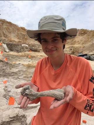 student holding a fossil