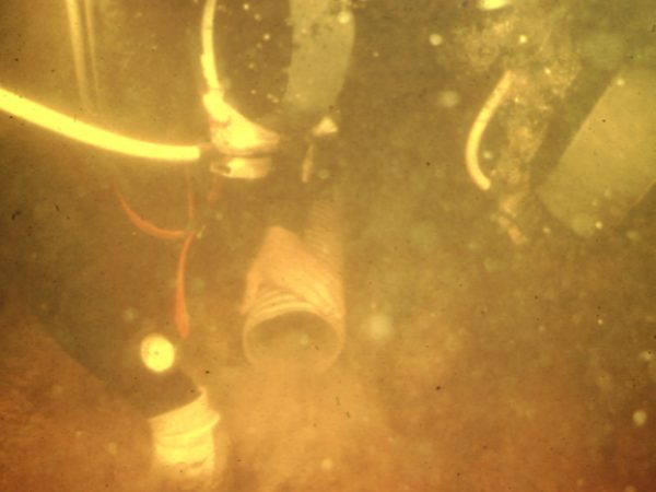 divers sucking up silt with a hose