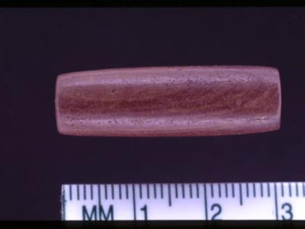 A red stone bead made from a non-native material.
