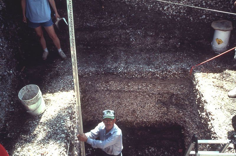 George Clark holds stadia rod for measurement, excavation C-5, Pineland 1990.