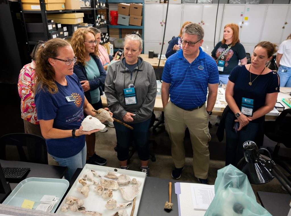 Museum researcher Jennifer Green showing tour participants items in the South Florida Archaeology Collection.