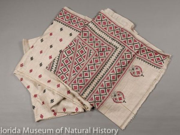 Sari of tropical silk (Antheraea paphia= A. mylitta), made in Gujarat, India. The Gujarati embroidery was done by hand, and represents five months of work. Background is natural colored, reeled silk. Measures 118 cm X 625 cm.