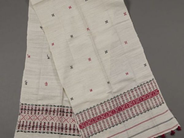 Woman’s chaddar composed of eri silk (Samia ricini), handwoven by women in Assam, India. The eri silk is natural colored and handspun. Brocaded with black and red acrylic threads in traditional Assamese motifs. Measures 56 cm x 203 cm