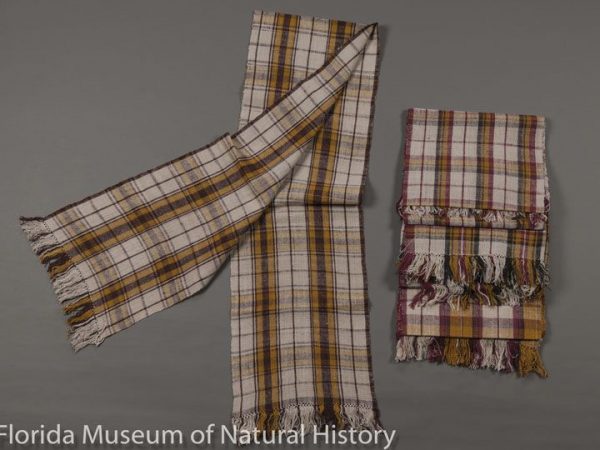 Handwoven scarves of eri silk (Samia ricini) made in Meghalaya, India. Plaids created using stick lac (Laccifer lacca) for red and brown, wild turmeric (Curcuma aromatica) for orange and yellow, logwood for blackish, and natural colored eri silk. Plaid weaving was introduced to Meghalaya in the 1770s by Scottish missionaries. Left scarf measures 29 cm X 180 cm and right scarf measures 29 cm x 184 cm.