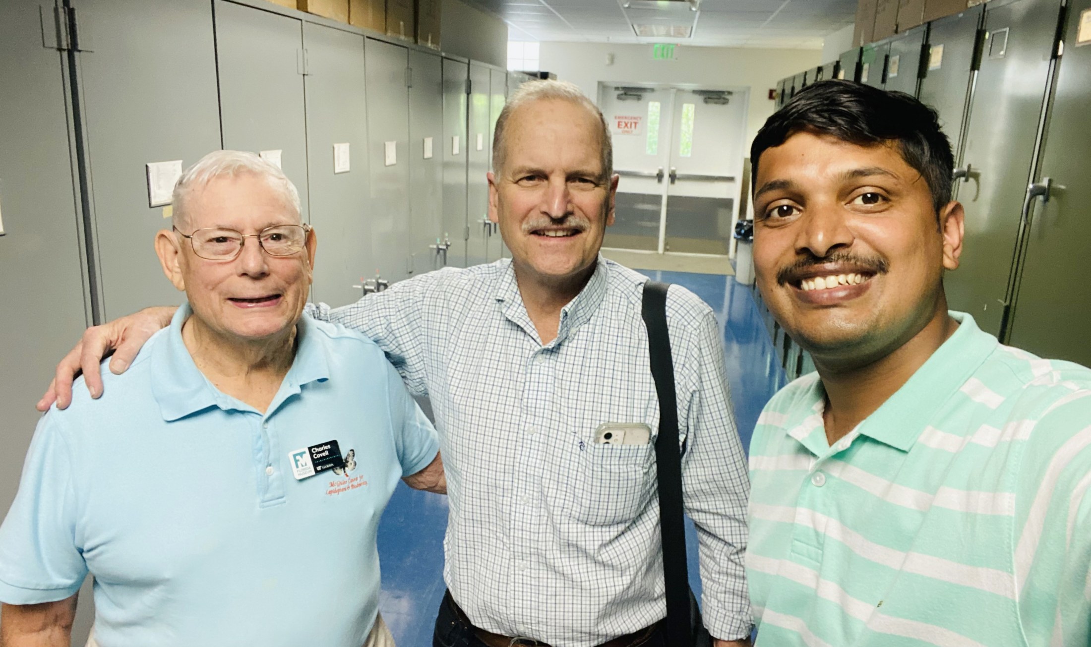 Three men standing in hallway