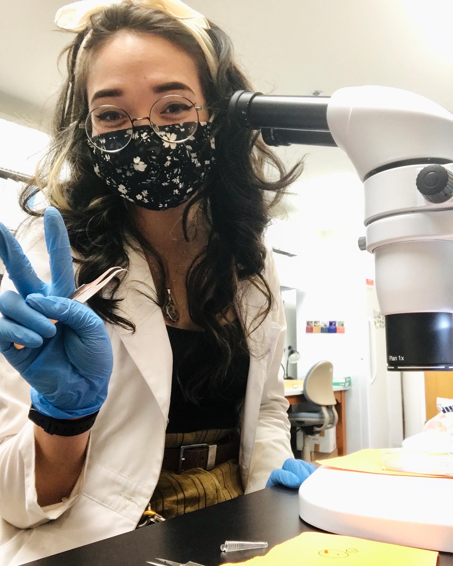 Woman sitting next to microscope