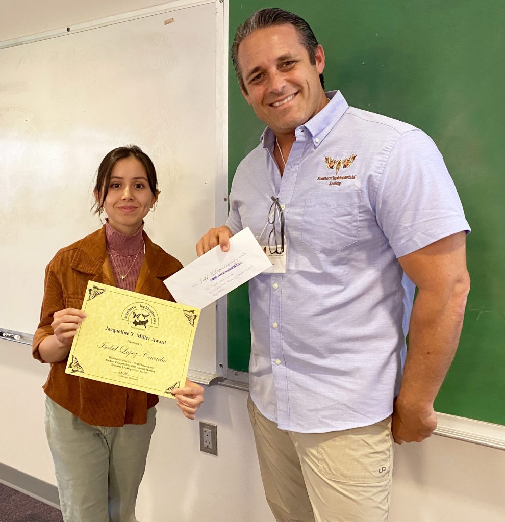 Picture of two people standing and holding an award certificate.