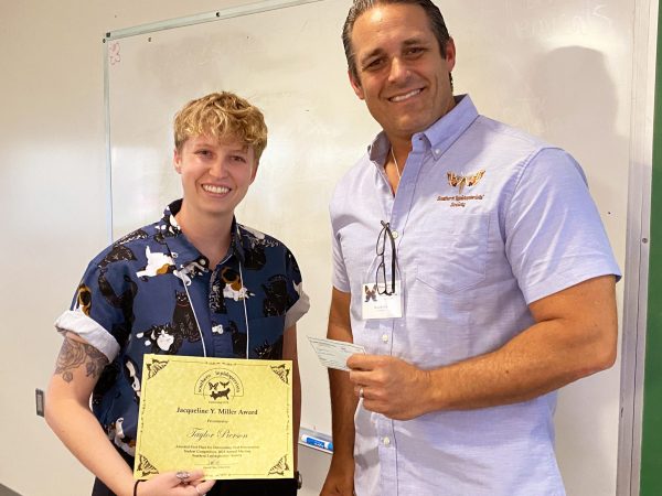 Picture of two people standing and holding an award certificate.
