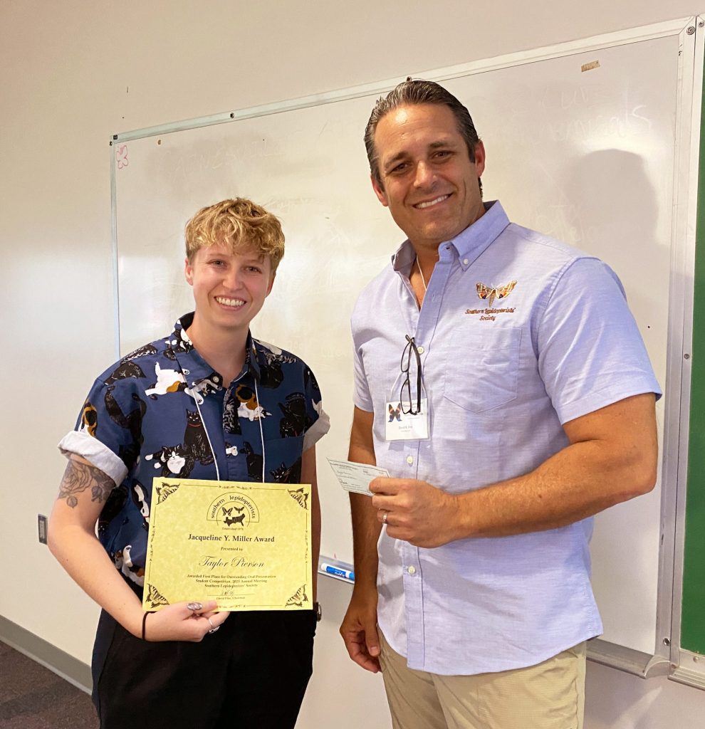 Picture of two people standing and holding an award certificate.
