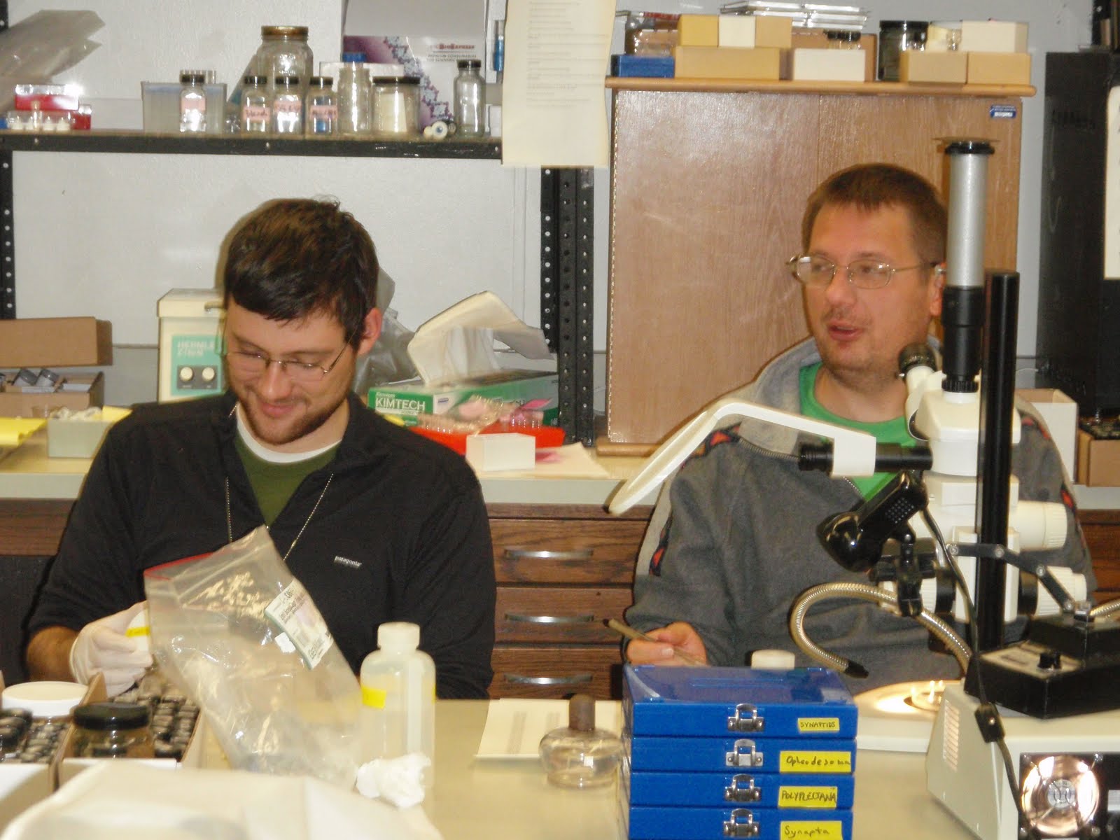 Nat and Art at a desk with a microscope