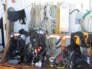 piles of dive gear on the boat deck