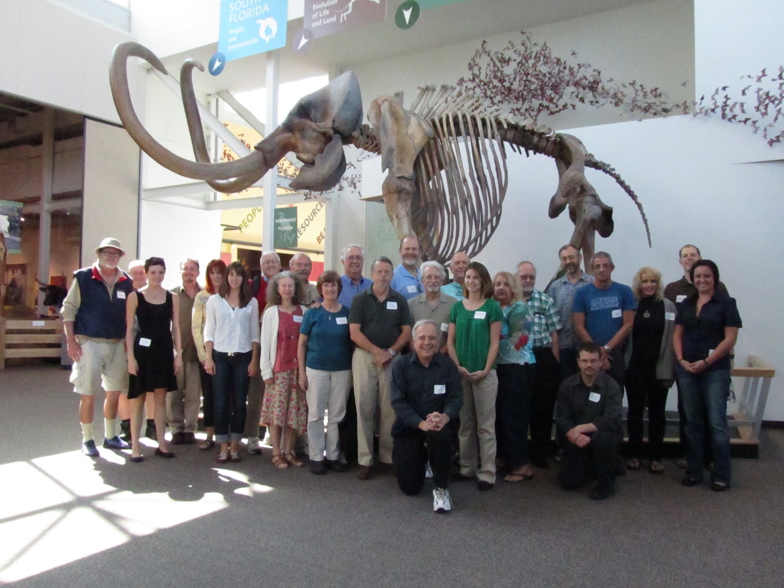 meeting attendees posing for a photo in front of the mastadon skeleton at Powell Hall