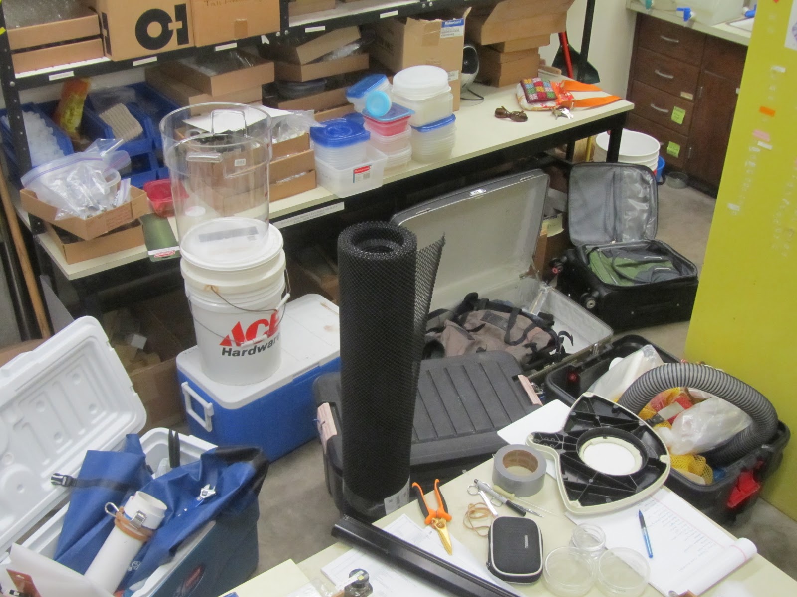 buckets, coolers, tupperware and other gear filling the tables and floor in the lab