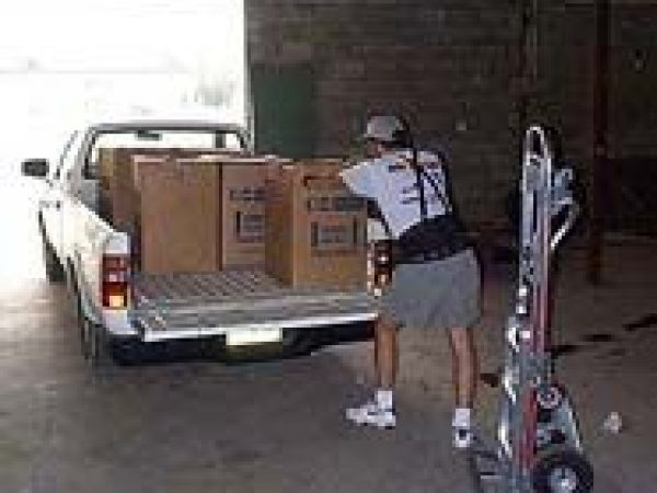 man loading collection boxes into truck