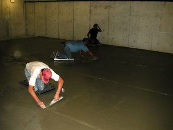 men smoothing the concrete floor in the collection room