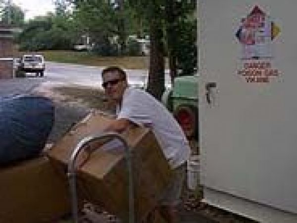 man moving box of collection items on dolly