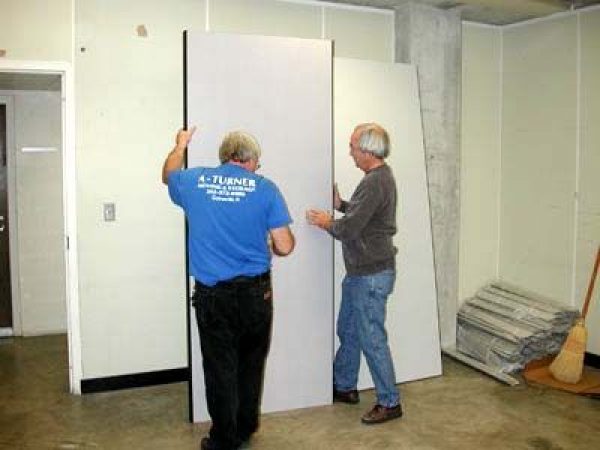 workers hanging up drywall for collection room