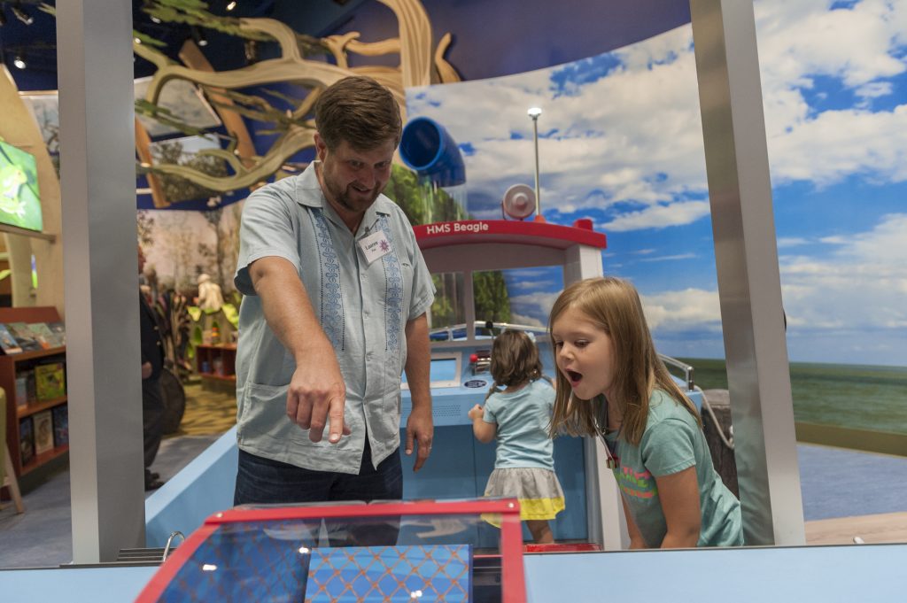 A family uses the Cedar Key fishing boat interactive station in the Discovery Zone exhibit.